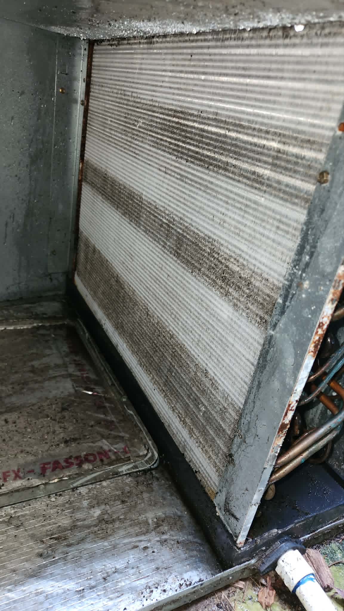 The same evaporator coil during cleaning, fins visibly restored